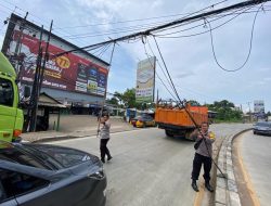 Anggota Polres Kota Tangerang Rapihkan Kabel Jaringan Internet yang Terseret di Tanah