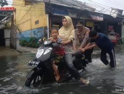 Polisi Bantu Pengendara Roda Dua yang Kesulitan Terobos Genangan Air di Jakbar